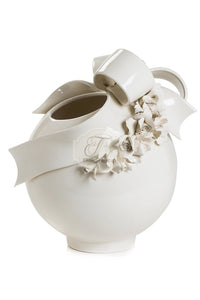 a white vase filled with flowers on a table 